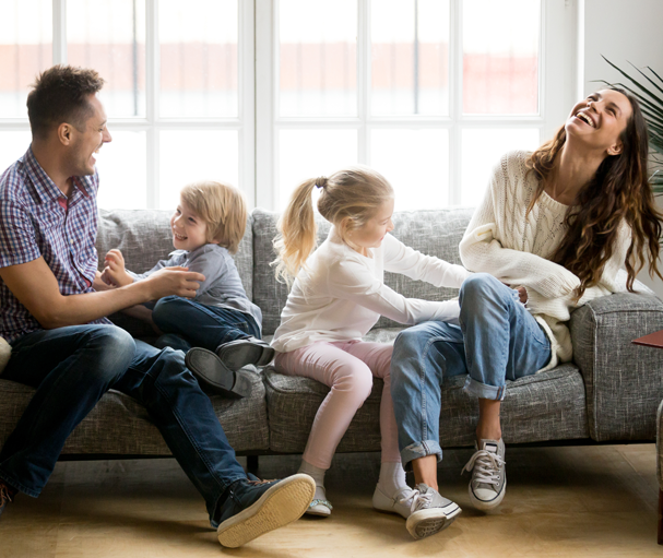 A Family laughing and enjoying on couch.